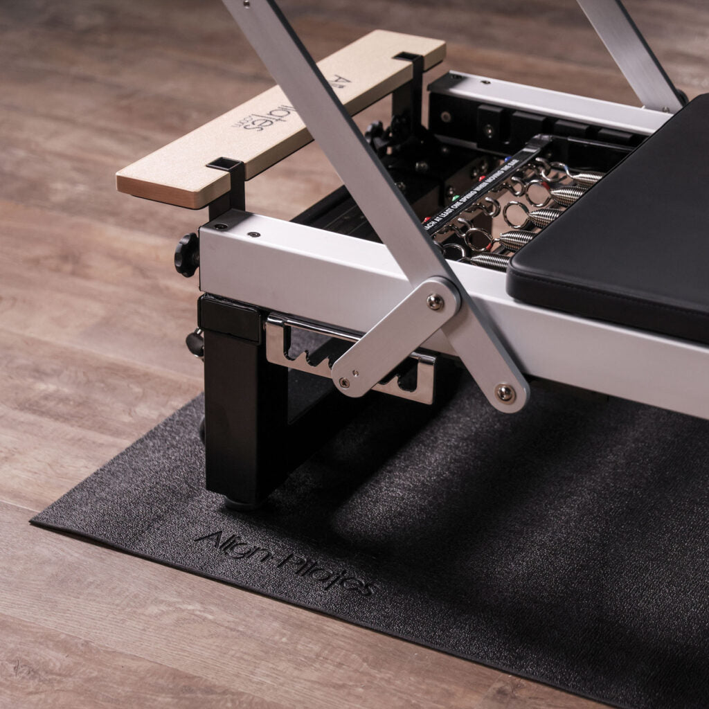 Align Pilates Reformer auf der schwarzen Bodenschutzmatte mit geprägtem Logo